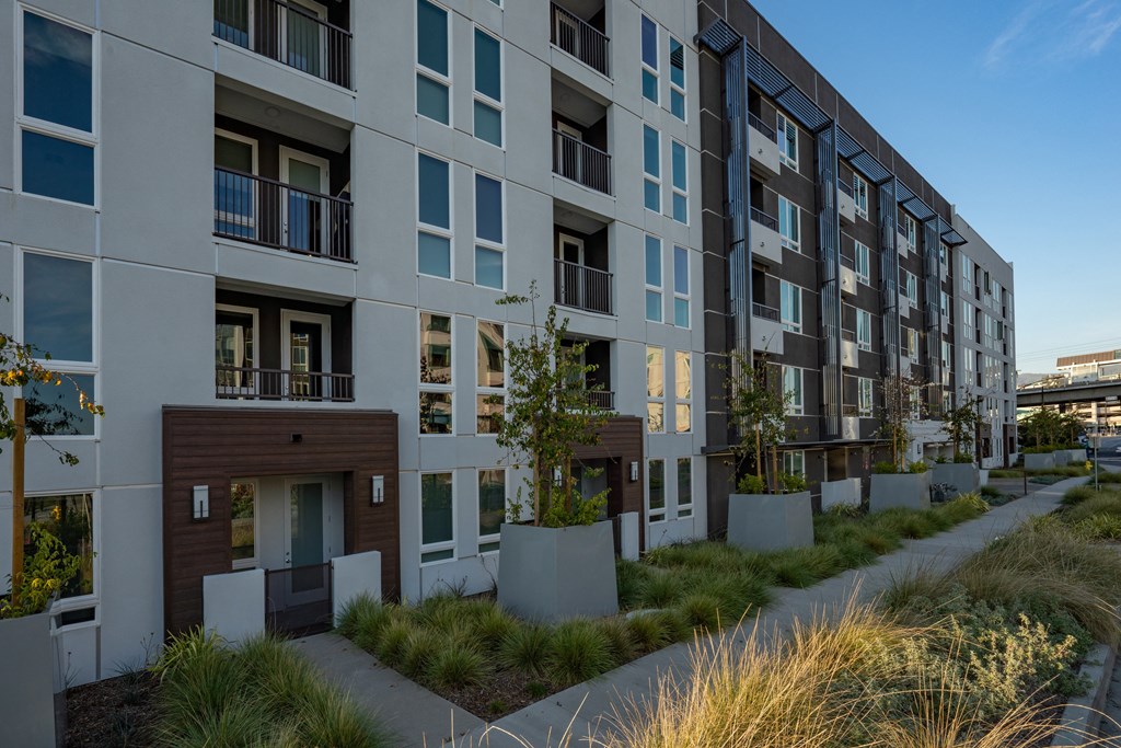 a large apartment building with a sidewalk in front of it