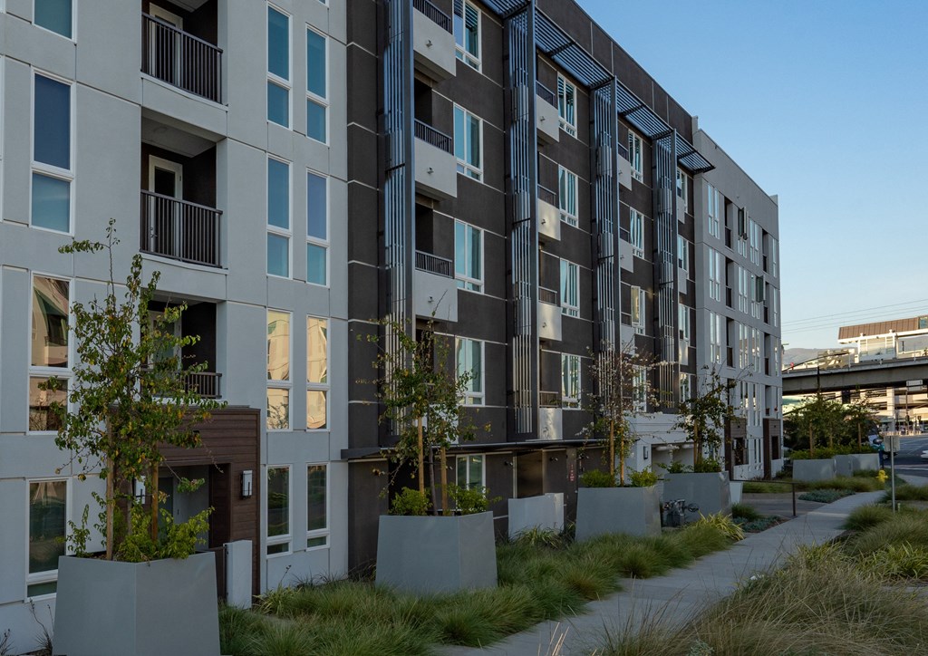 an apartment building with a sidewalk in front of it