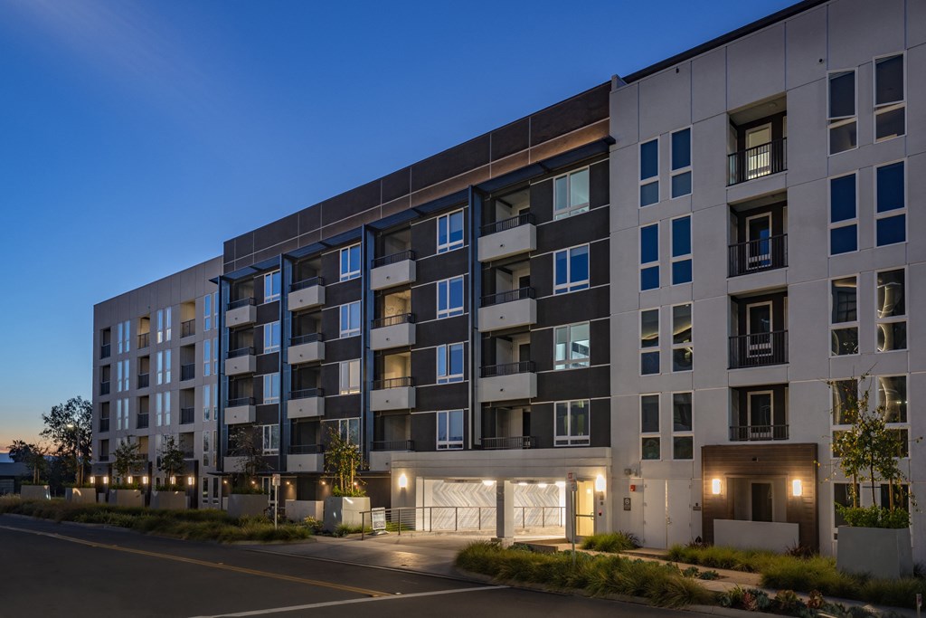 an exterior view of an apartment building at night