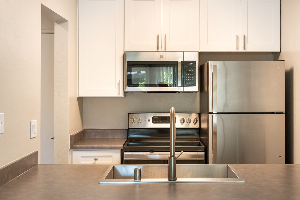 a kitchen with stainless steel appliances and white cabinets