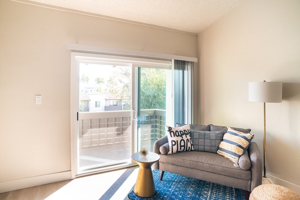 a living room with a couch and a door to a balcony