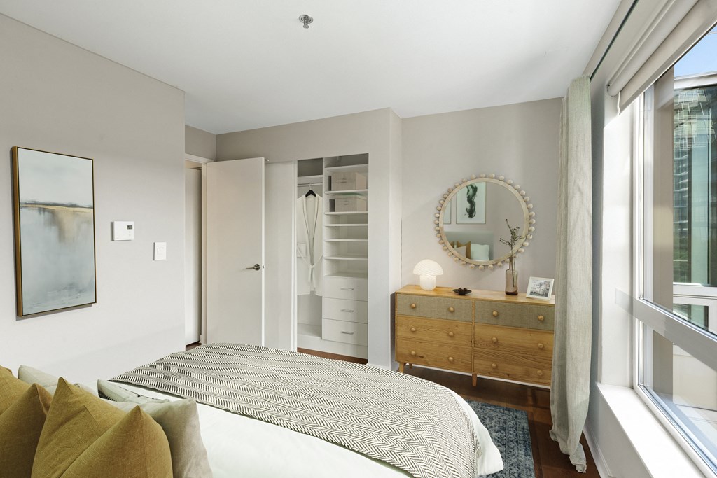 a bedroom with a large bed and a dresser with a mirror