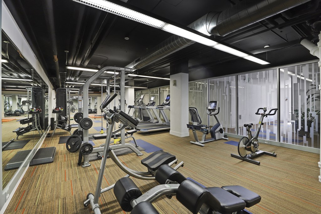 a gym with weights and other exercise equipment on a wooden floor