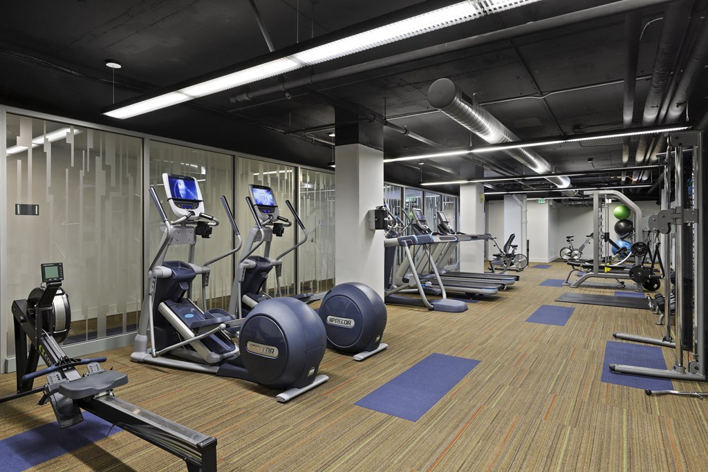 a gym with exercise equipment and weights in a building