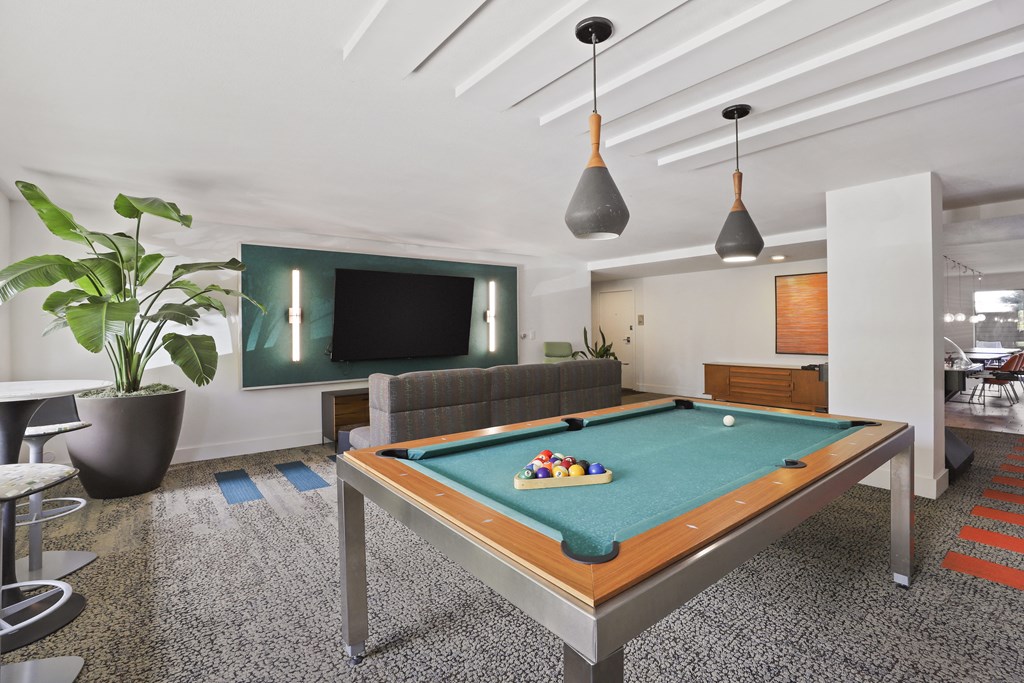 a living room with a pool table and a television