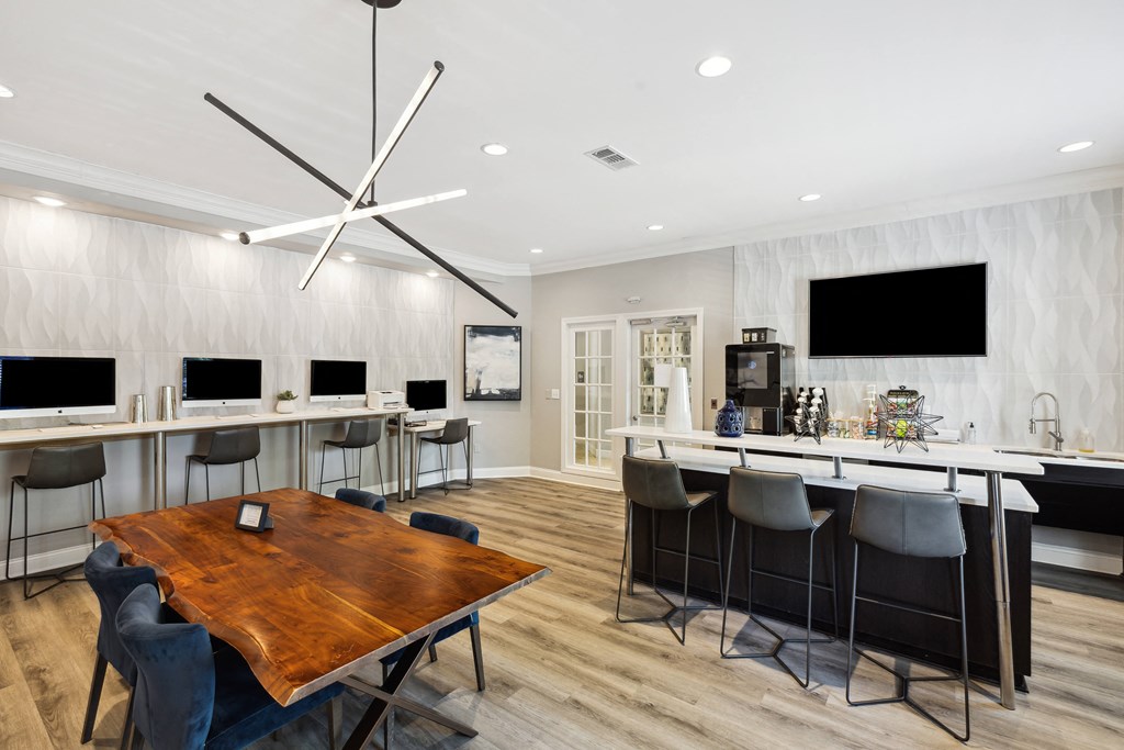 a dining room with a table and chairs and a bar with televisions