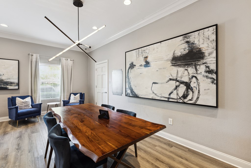 a dining room with a table and chairs and a large painting on the wall