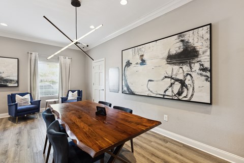 a dining room with a table and chairs and a large painting on the wall