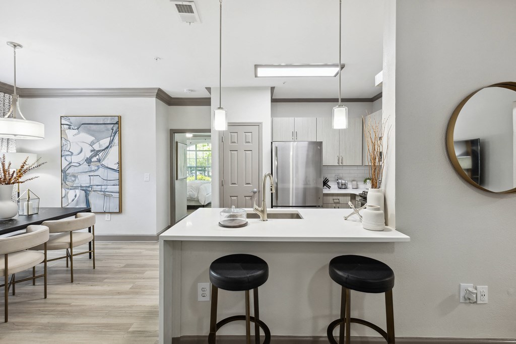 a kitchen with a white counter top and black stools