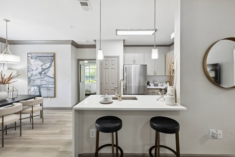 a kitchen with a white counter top and black stools