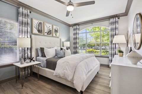 a bedroom with a bed and a large window