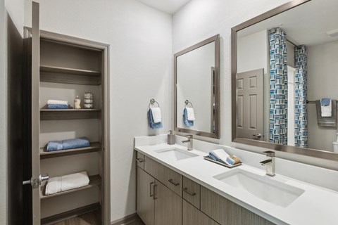 a bathroom with two sinks and a mirror and a closet
