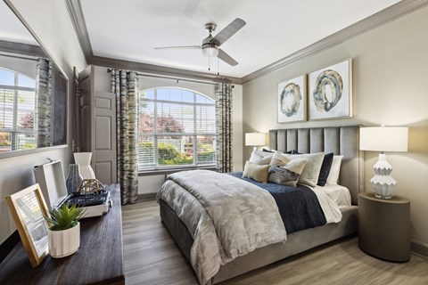 a bedroom with a large bed and a ceiling fan