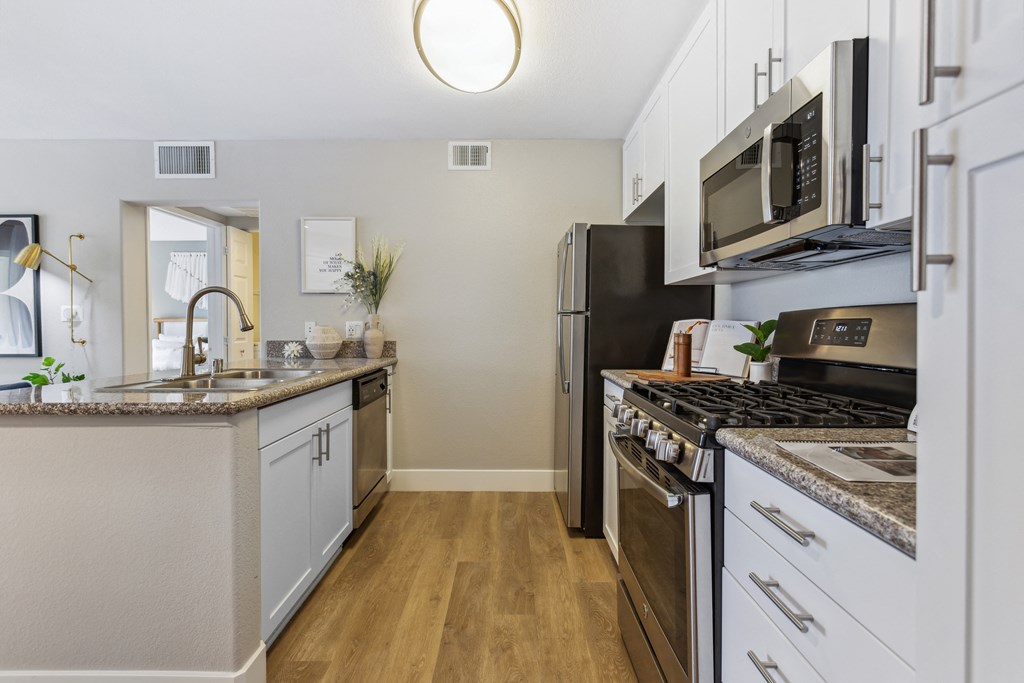 a kitchen with white cabinets and stainless steel appliances and a counter top