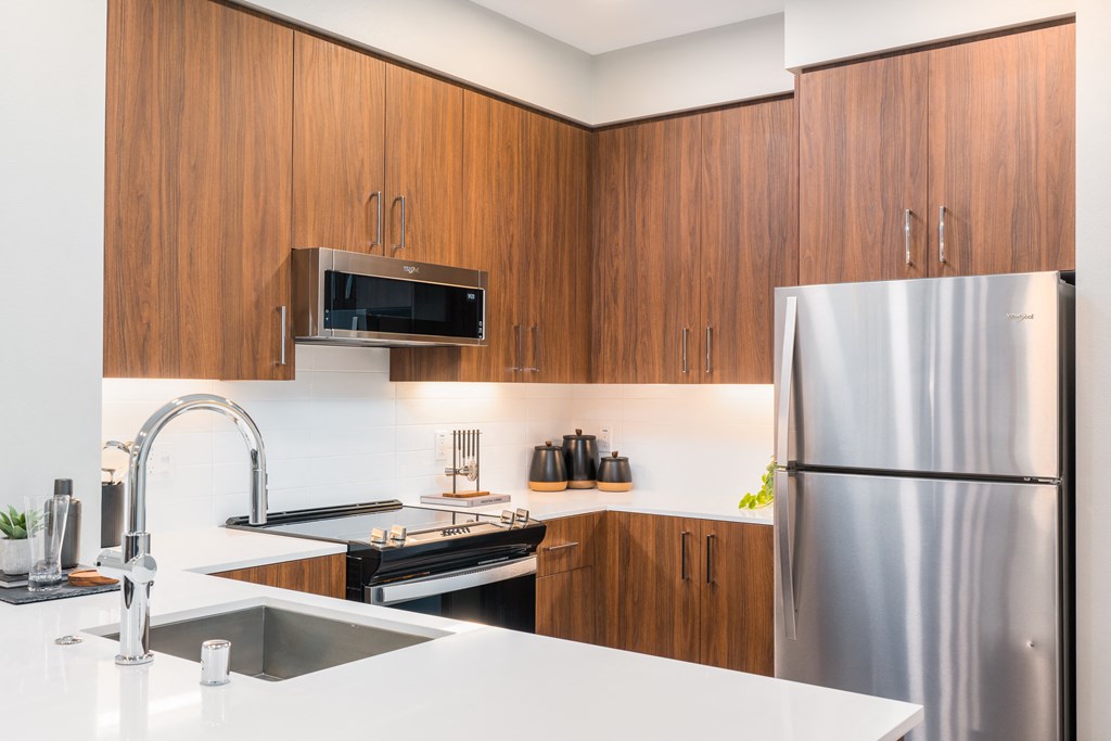 a kitchen with stainless steel appliances and white counter tops