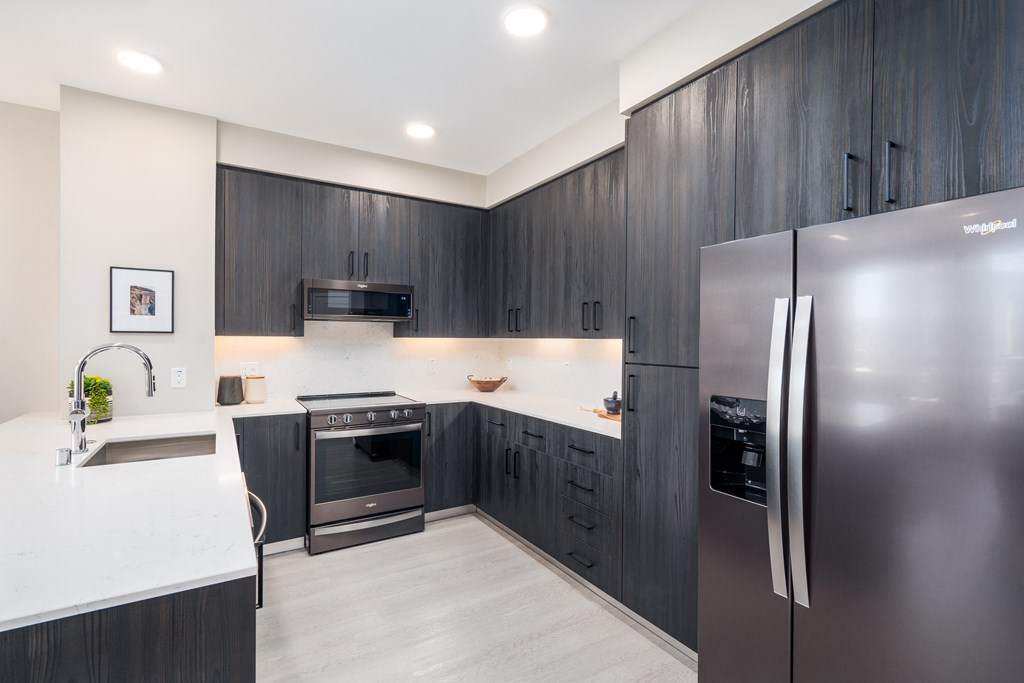 a kitchen with stainless steel appliances and dark wood cabinets