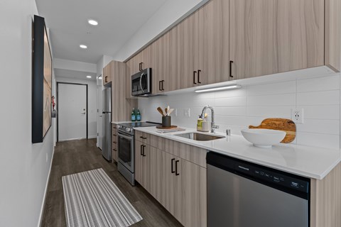 A modern kitchen with wooden cabinets and stainless steel appliances.