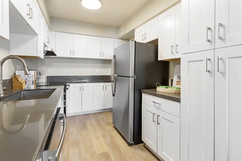 a large kitchen with stainless steel appliances and white cabinets