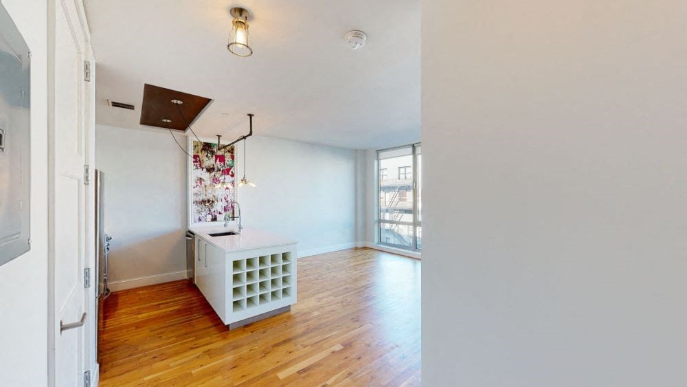 A room with a white cabinet and a wooden floor.