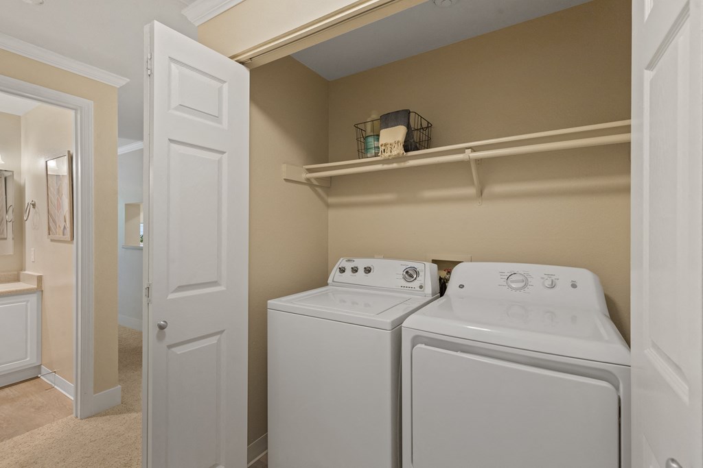 a white washer and dryer in a laundry room with a white door