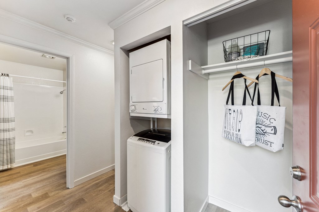 a laundry room with a washer and dryer and a door to a closet
