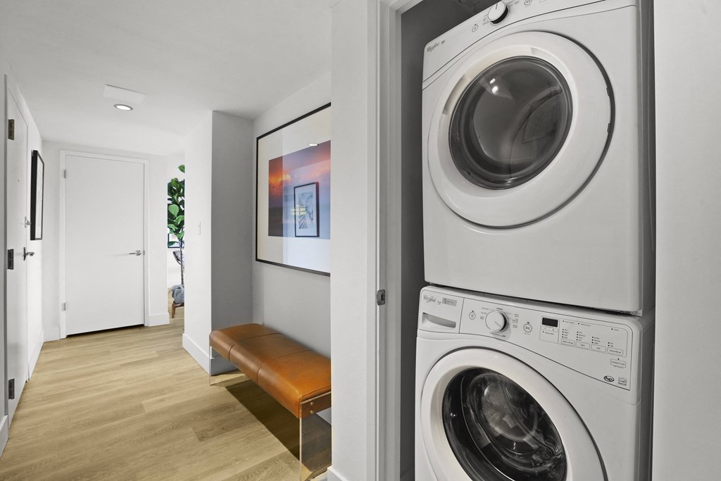 a white washer and dryer in a laundry room with a bench