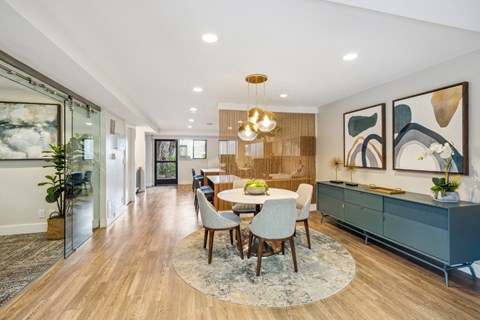 a dining room with a white table and chairs and a blue cabinet