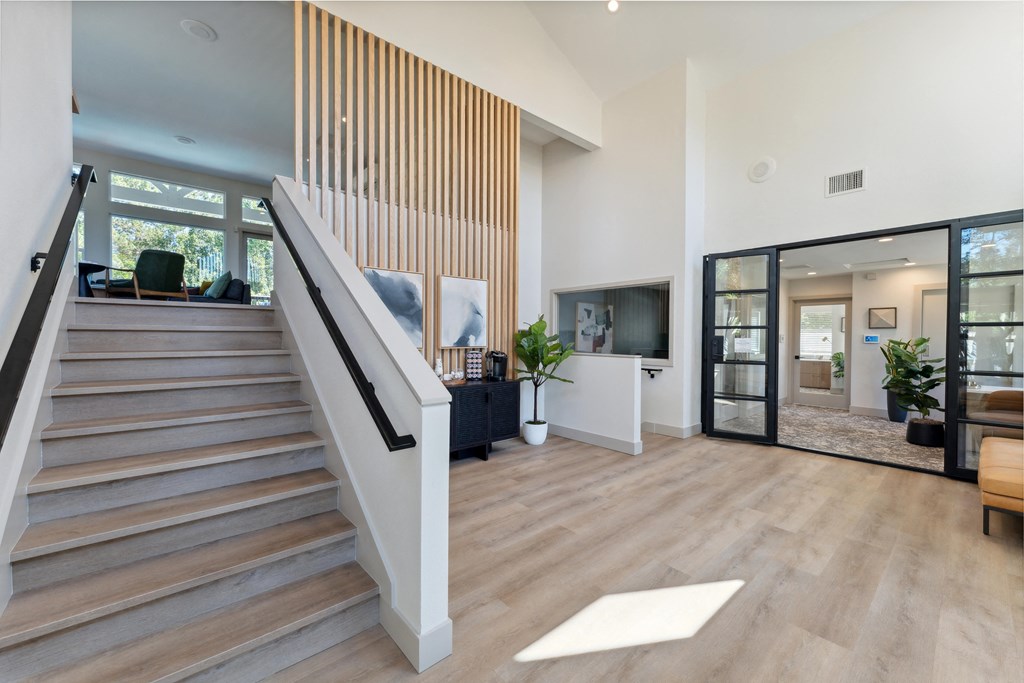 a living room with a staircase and a tv in a house