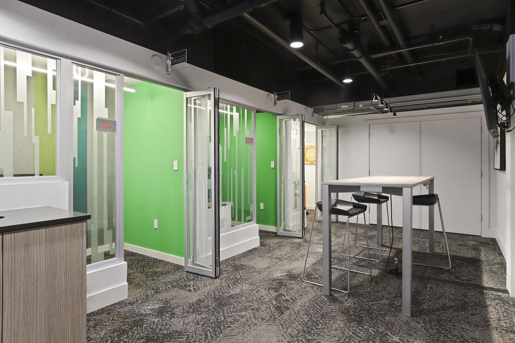 a meeting room with green walls and tables and chairs