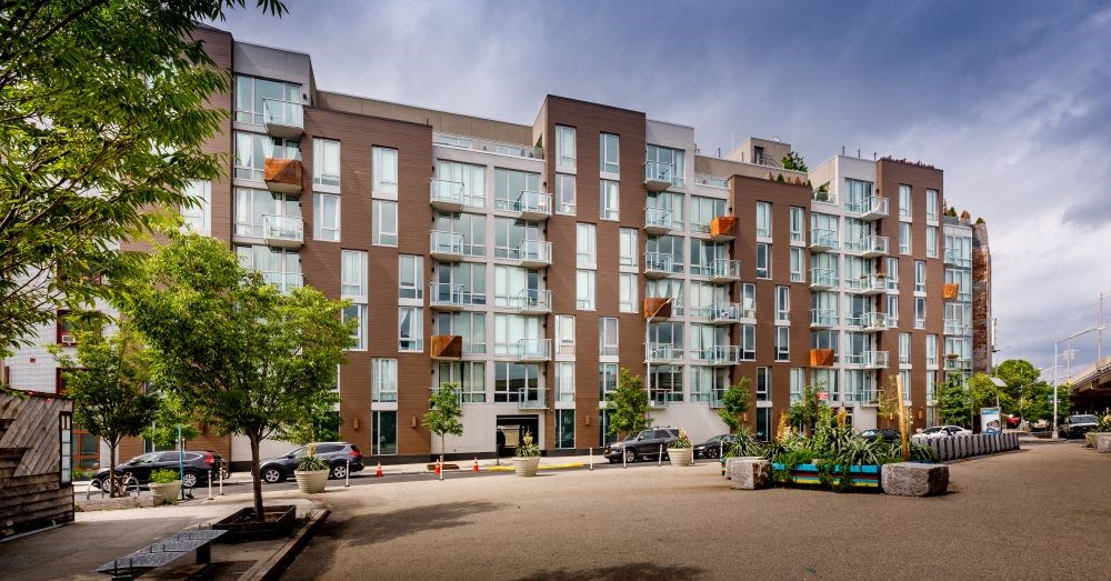 A large apartment building with a parking lot in front.