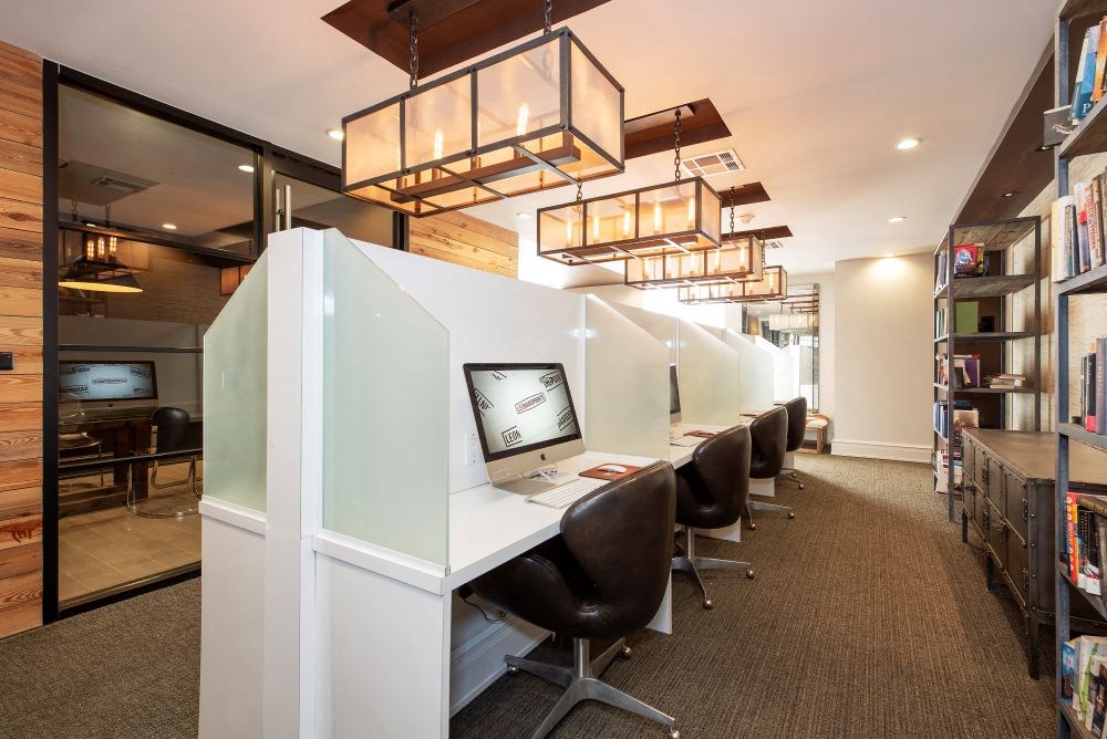 A room with a long white desk and chairs.