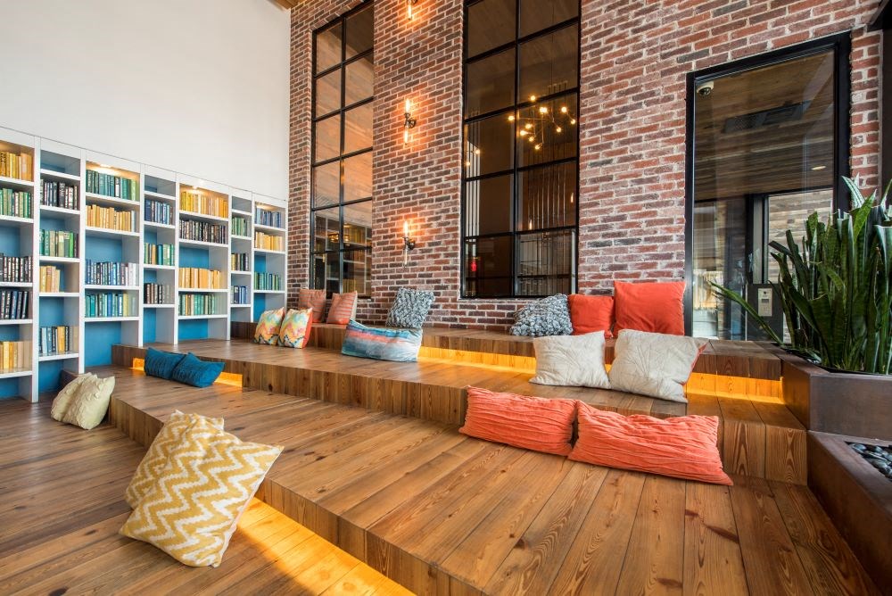 A room with a wooden floor and a brick wall with a window.