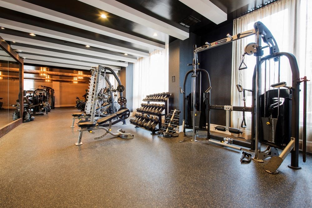 A gym with a variety of equipment including weights and machines.