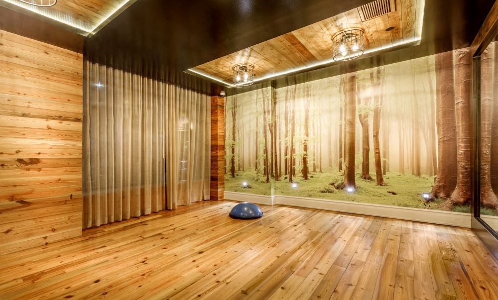 A room with wooden floors and a wall mural of a forest scene.