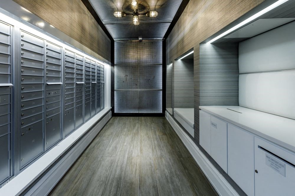 A long hallway with a row of filing cabinets on the left and a row of white cupboards on the right.