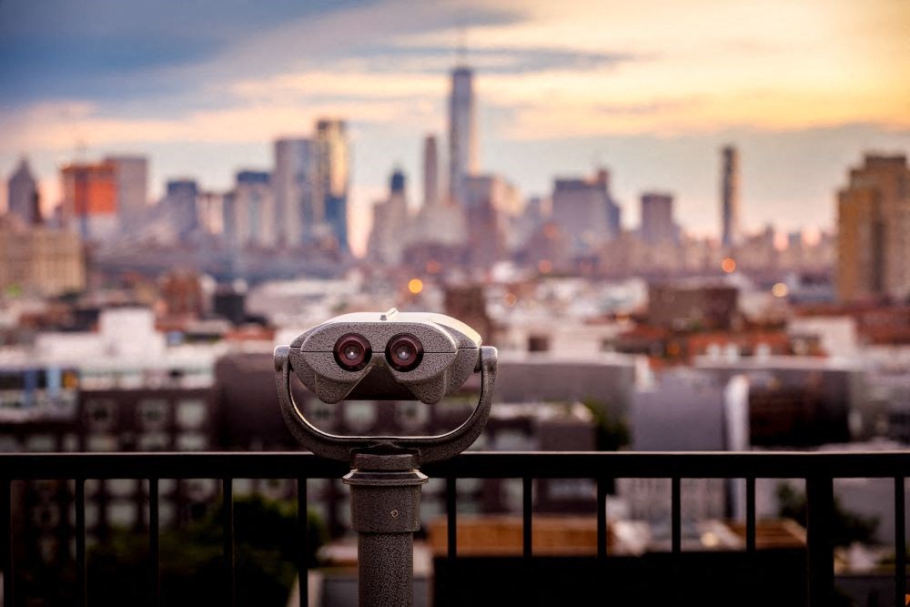 A pair of binoculars overlooking a city skyline.