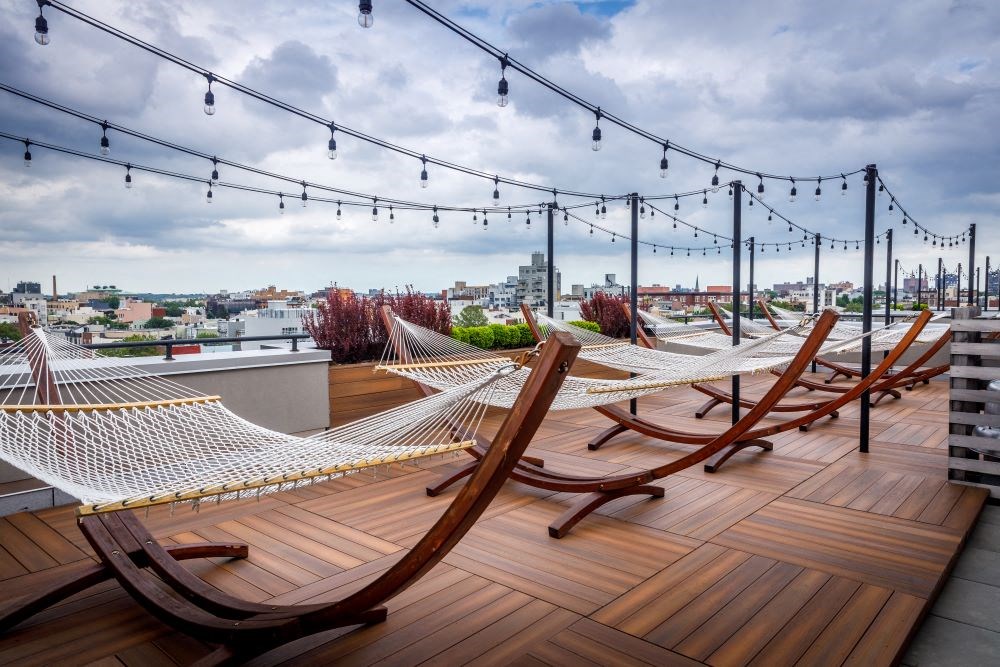 A rooftop with hammocks and string lights.
