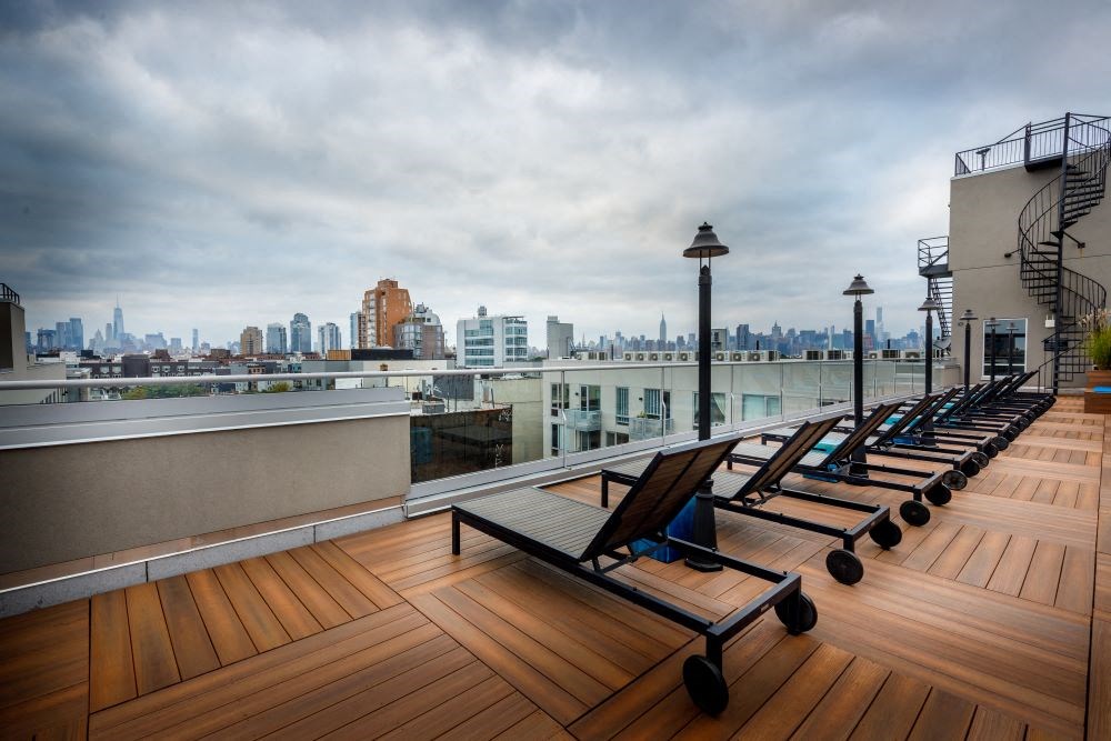 A rooftop with chairs and a city view.