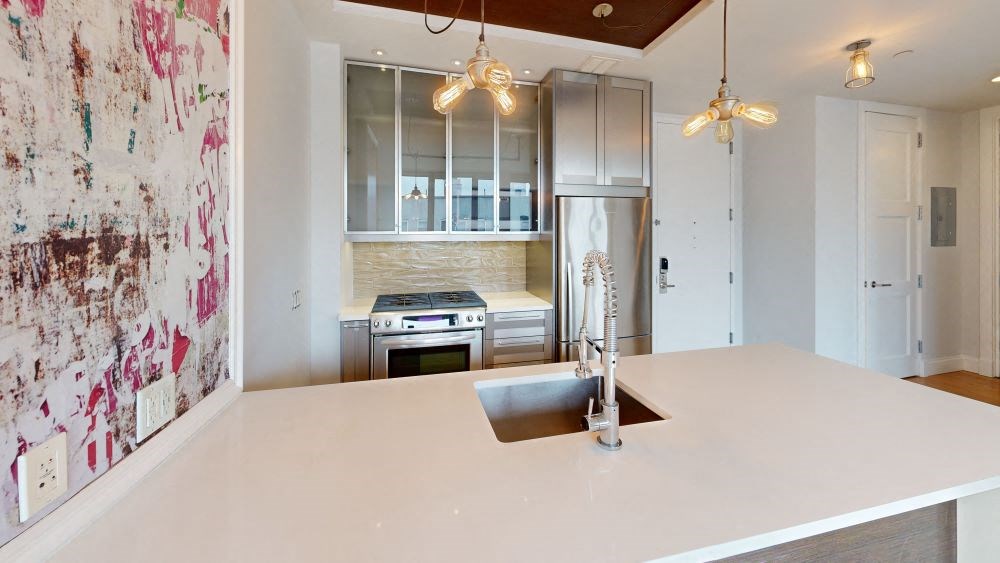 A modern kitchen with a large island and stainless steel appliances.