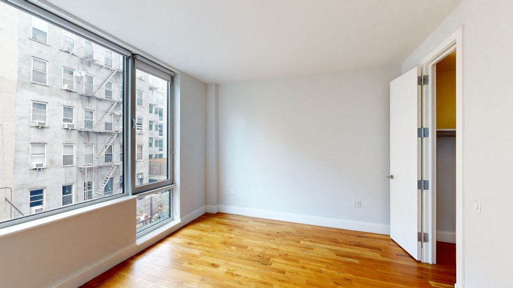 Empty room with wooden floor and white walls.