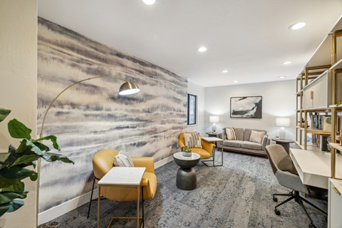 A small library with a large wall mural and a variety of seating options.