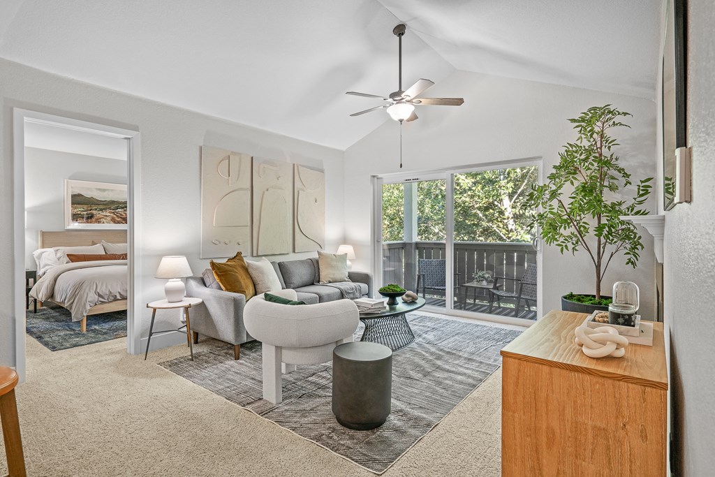 an open living room with a couch and a coffee table and a balcony