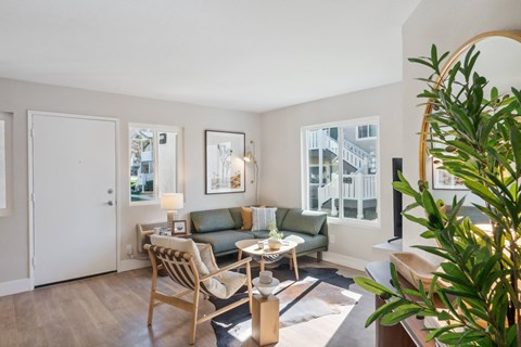 a living room with a couch and a chair and a window