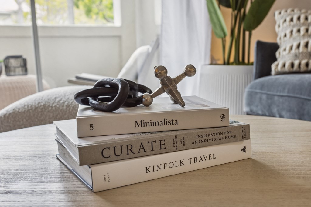 a stack of books on a coffee table with a statue of a cross on top