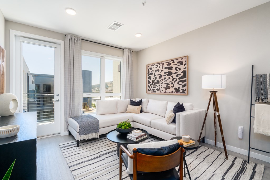 a living room with a white couch and a table and a window