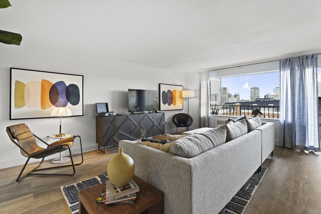 a living room with a gray couch and a large window