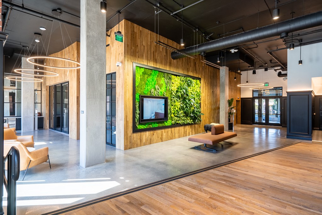 a living wall in an office lobby with furniture and a tv