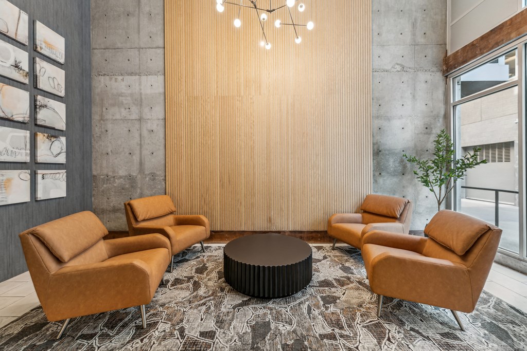 a lobby with brown couches and chairs and a round table