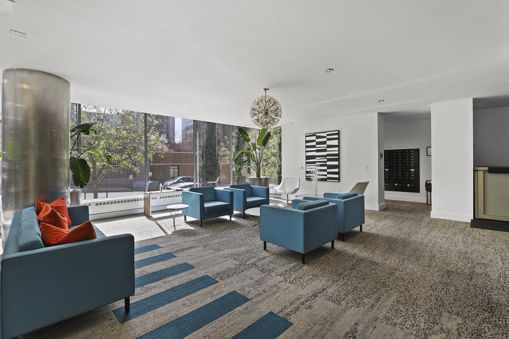 a living room with blue couches and chairs and a large window