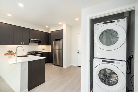 a washer and dryer in a living room with a kitchen